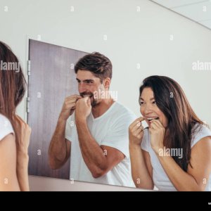 pareja-mirandose-en-el-espejo-y-sonriendo-usar-el-hilo-dental-para-limpiar-los-dientes-hombre-...jpg
