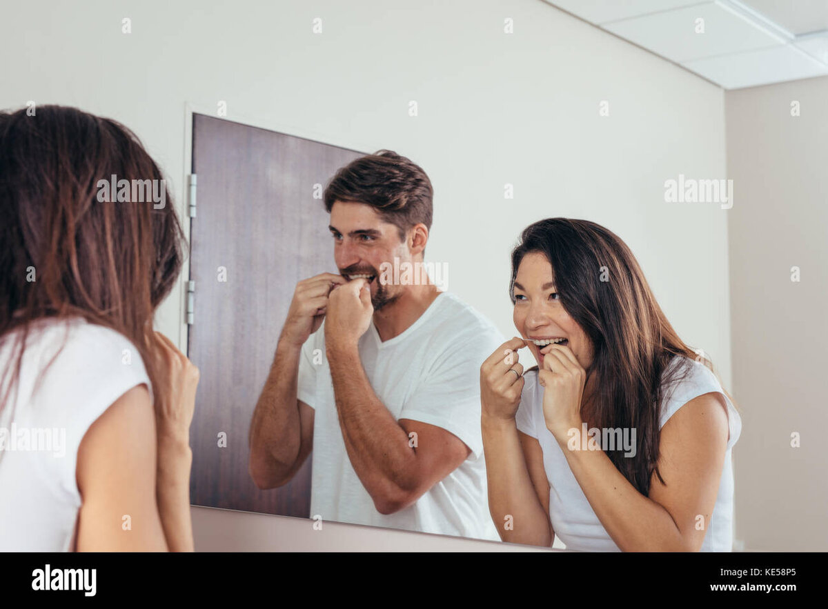 pareja-mirandose-en-el-espejo-y-sonriendo-usar-el-hilo-dental-para-limpiar-los-dientes-hombre-...jpg
